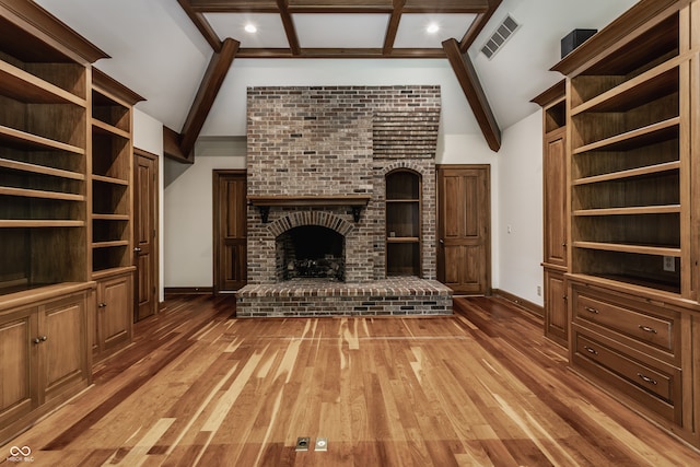 unfurnished living room with beam ceiling, wood-type flooring, a fireplace, and high vaulted ceiling