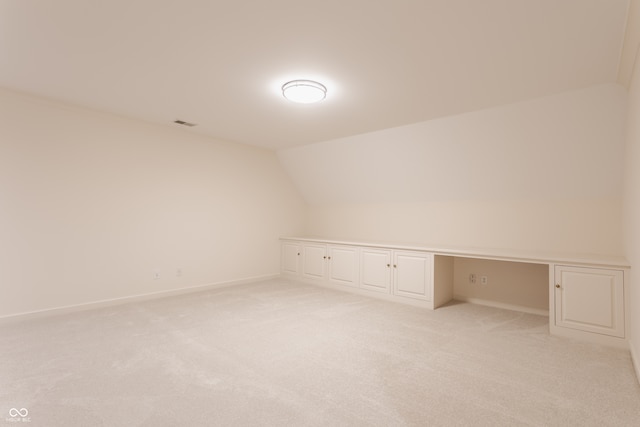 bonus room featuring light colored carpet and vaulted ceiling