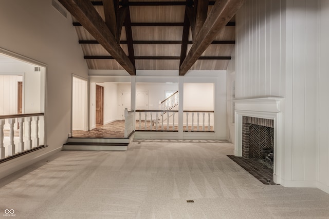 hallway featuring beam ceiling, light carpet, and high vaulted ceiling