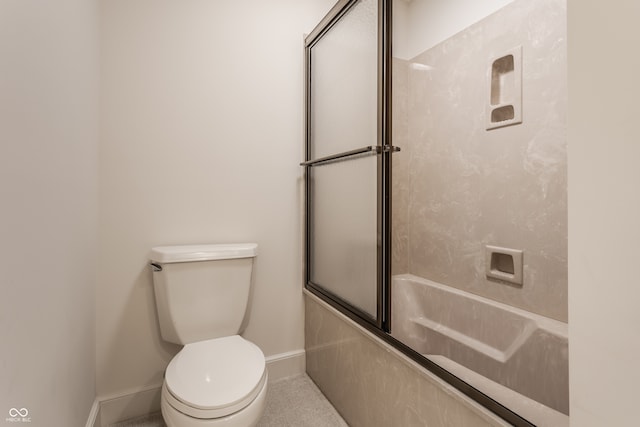 bathroom featuring toilet and combined bath / shower with glass door