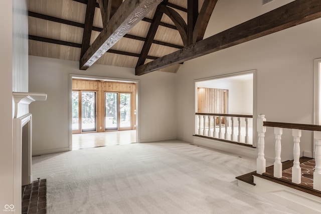 unfurnished living room with beam ceiling, wood ceiling, light carpet, and high vaulted ceiling