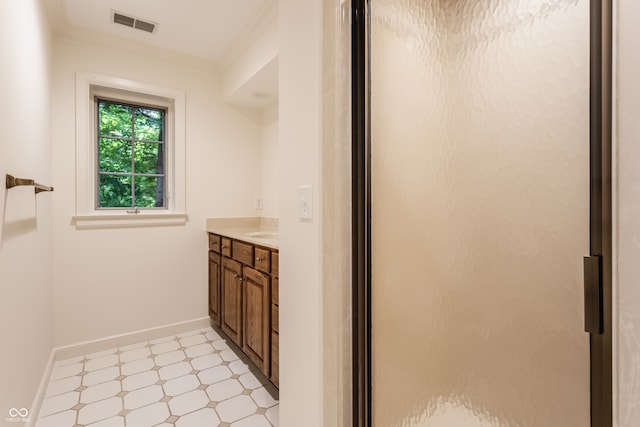 bathroom with crown molding, vanity, and walk in shower