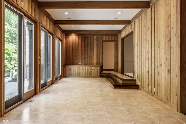 mudroom featuring beam ceiling, wooden walls, and light tile patterned flooring