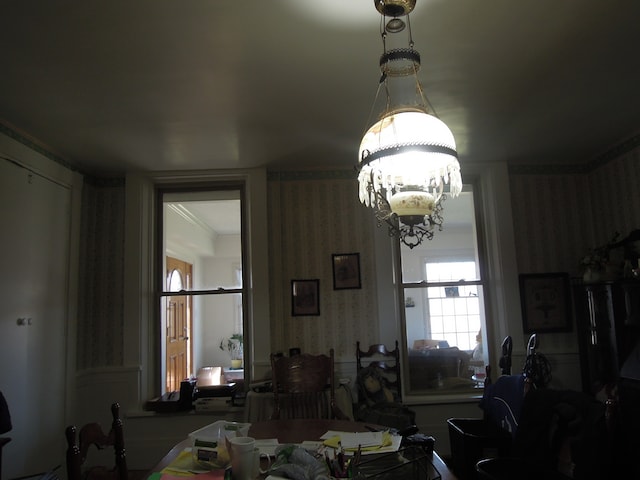 dining space with ornamental molding and a chandelier