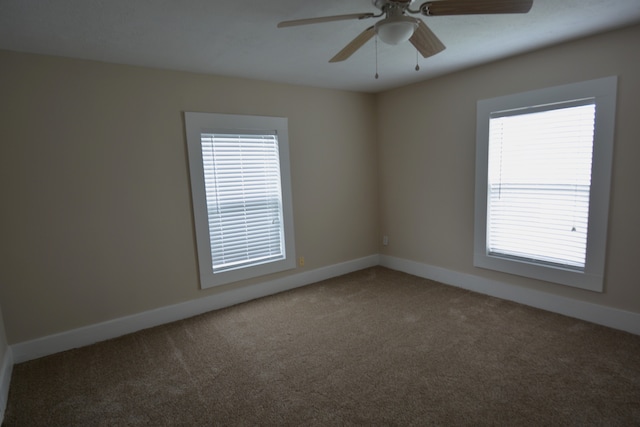 carpeted empty room featuring ceiling fan and a wealth of natural light