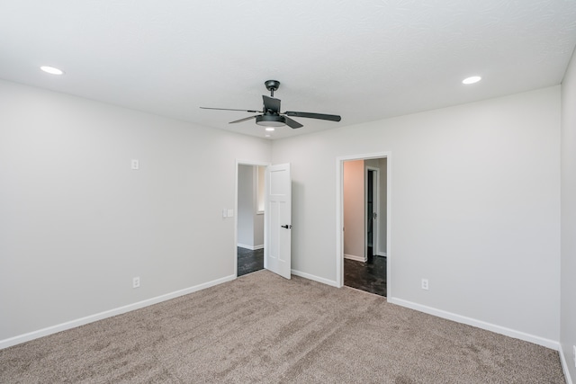 carpeted spare room featuring ceiling fan