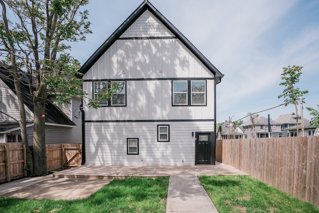 rear view of property with a yard and a patio