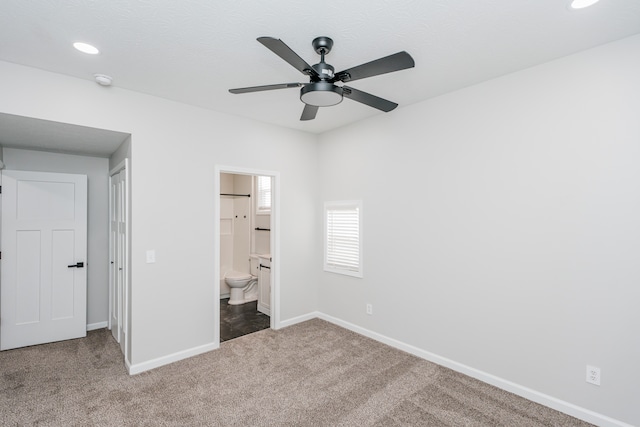 unfurnished bedroom featuring ceiling fan, ensuite bathroom, and carpet floors