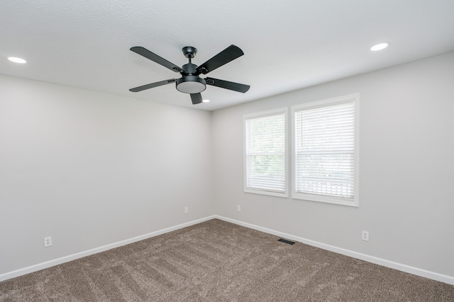 carpeted spare room with ceiling fan