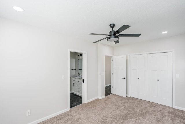 unfurnished bedroom with ceiling fan, carpet, ensuite bath, and a closet