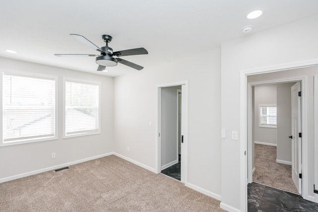 empty room featuring dark carpet and ceiling fan