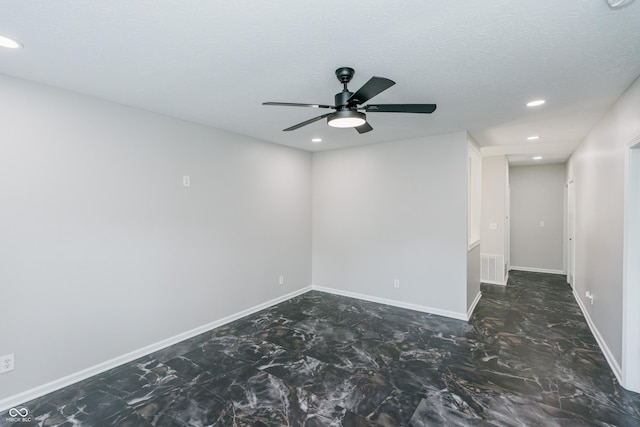 empty room featuring ceiling fan and a textured ceiling