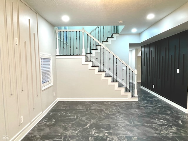 stairway with a textured ceiling