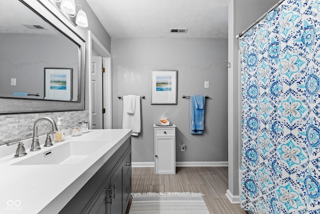 5220 Ariana Ct, Indianapolis, IN 46227 - bathroom featuring vanity, a textured ceiling, wood tiled floors, tasteful backsplash, and a shower with shower curtain