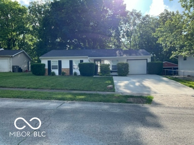 single story home featuring a garage and a front yard