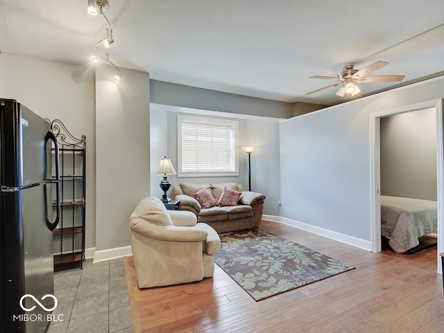 living room with ceiling fan and light wood-type flooring