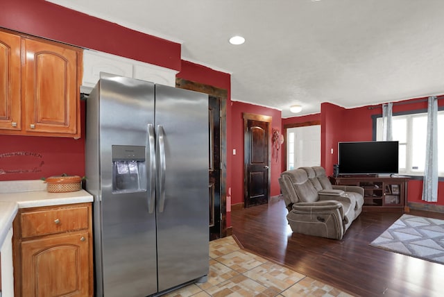 kitchen with stainless steel refrigerator with ice dispenser and light hardwood / wood-style floors