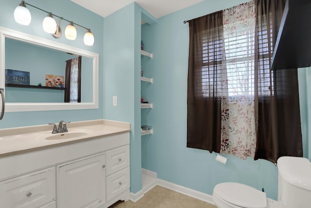 bathroom with tile flooring, toilet, and vanity