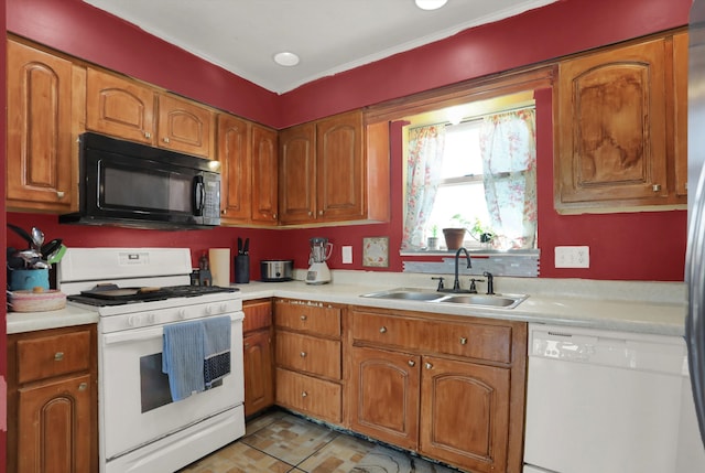 kitchen with white appliances, sink, and light tile floors