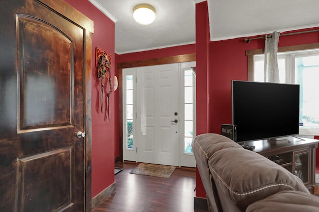 entryway with a textured ceiling, dark hardwood / wood-style flooring, and ornamental molding