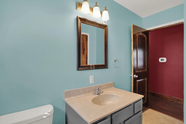 bathroom with hardwood / wood-style flooring, toilet, and vanity