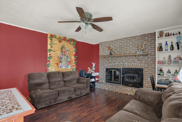 living room with dark hardwood / wood-style floors, ceiling fan, brick wall, a brick fireplace, and built in shelves