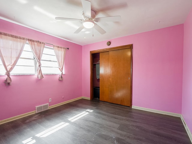 spare room with dark hardwood / wood-style flooring and ceiling fan