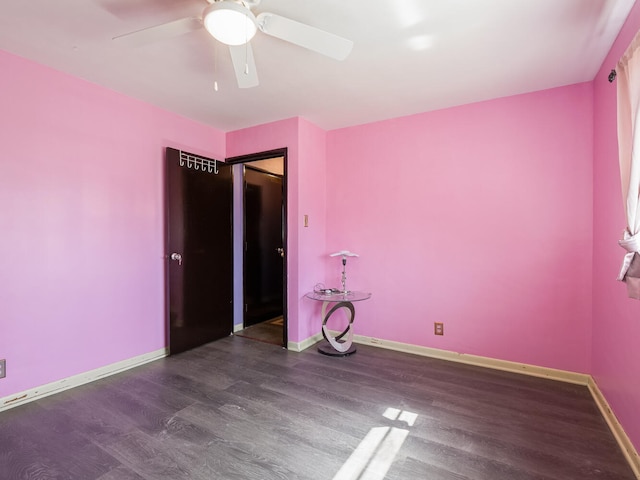 spare room featuring ceiling fan and dark wood-type flooring