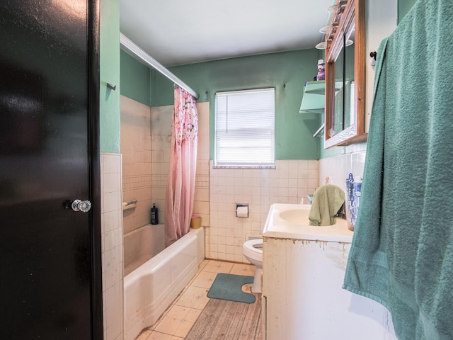 full bathroom with tile walls, shower / bath combination with curtain, tile floors, toilet, and vanity