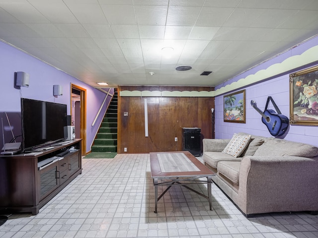 tiled living room featuring wood walls