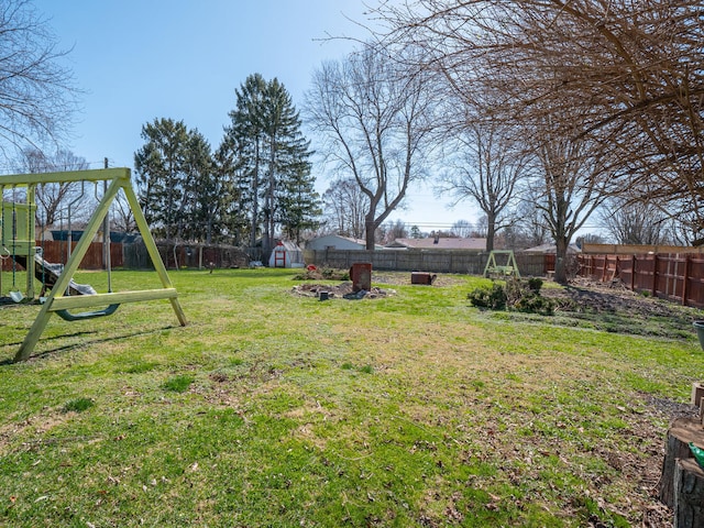 view of yard with a storage unit and a playground