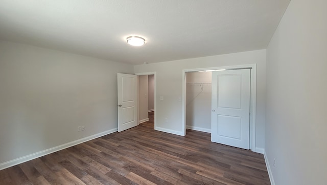 unfurnished bedroom featuring a closet and dark wood-type flooring