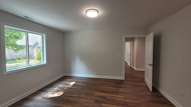 unfurnished room featuring dark hardwood / wood-style flooring