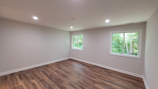 spare room with dark hardwood / wood-style flooring and a healthy amount of sunlight