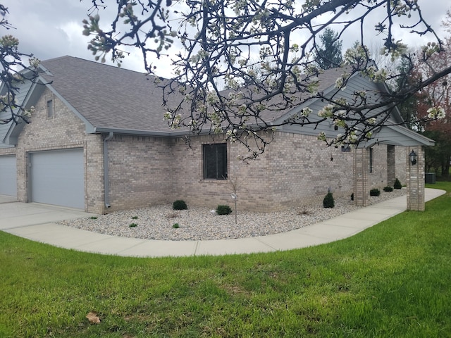 view of side of property featuring a lawn and a garage