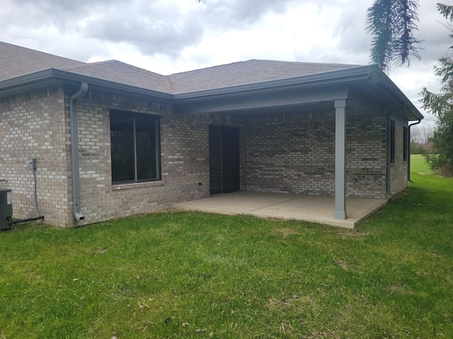 rear view of property featuring a patio area and a lawn