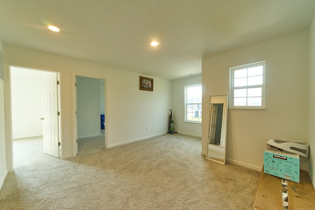 spare room featuring light carpet