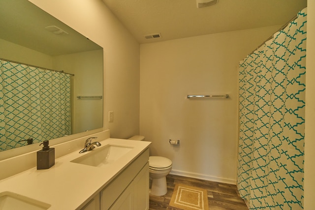 bathroom featuring hardwood / wood-style flooring, toilet, and vanity