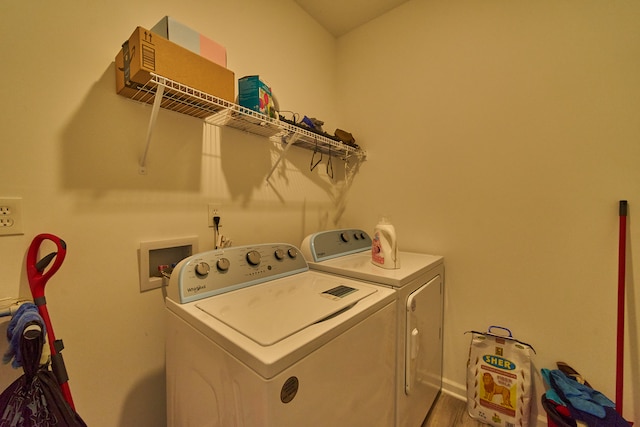 clothes washing area featuring hardwood / wood-style flooring, washer hookup, and washing machine and clothes dryer