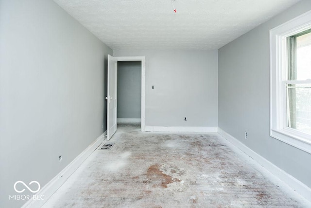 unfurnished room featuring a textured ceiling