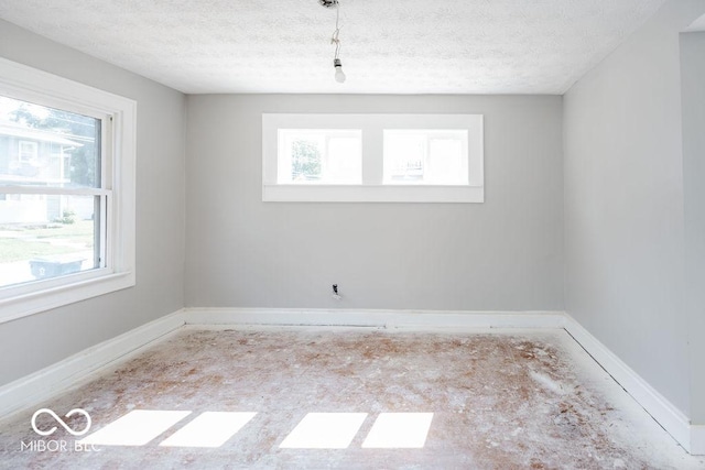 unfurnished room featuring a healthy amount of sunlight and a textured ceiling