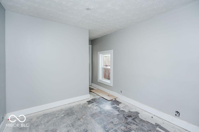 unfurnished room with a textured ceiling