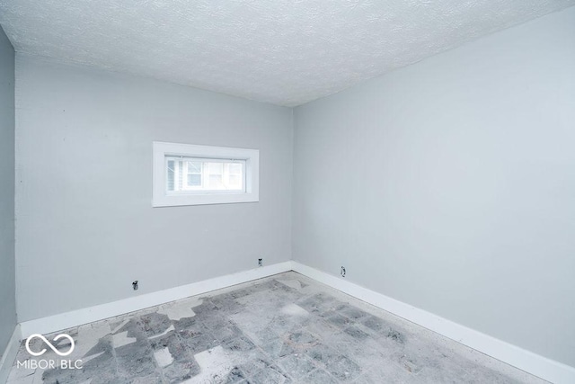 unfurnished room with a textured ceiling