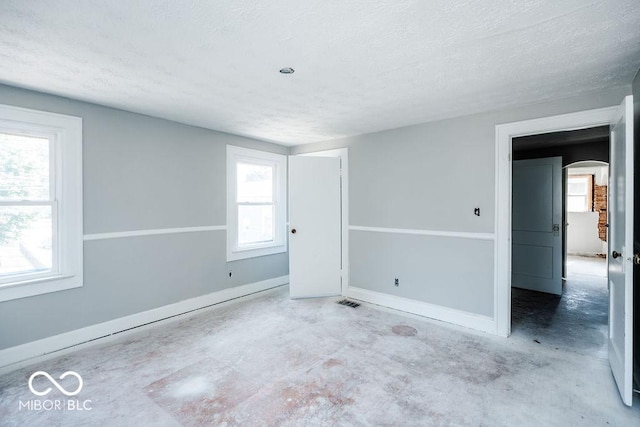 empty room featuring concrete flooring and a textured ceiling