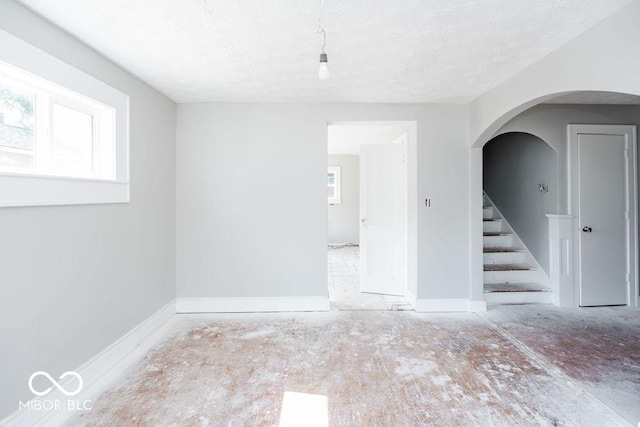 spare room with plenty of natural light and a textured ceiling