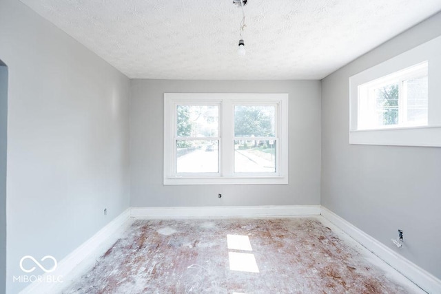 unfurnished room featuring a healthy amount of sunlight and a textured ceiling