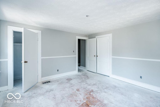 unfurnished bedroom featuring a textured ceiling and a closet