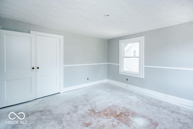 unfurnished bedroom with concrete flooring, a closet, and a textured ceiling