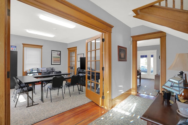 office with french doors and light hardwood / wood-style flooring