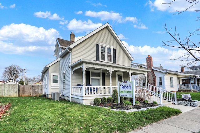 view of front of property with central air condition unit, a front lawn, and covered porch